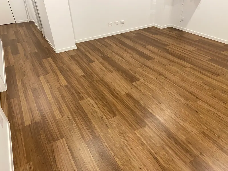 New wood-look vinyl plank floor clean and polished in an empty room