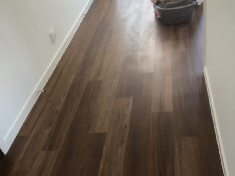 New vinyl plank hallway dulled by builder's dust before cleaning