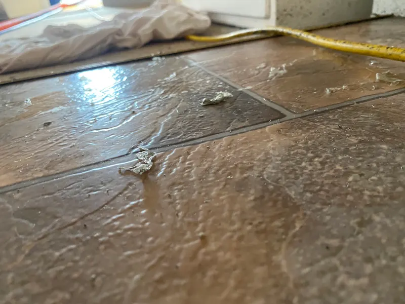 Close-up of old polish layers lifting off vinyl during a strip