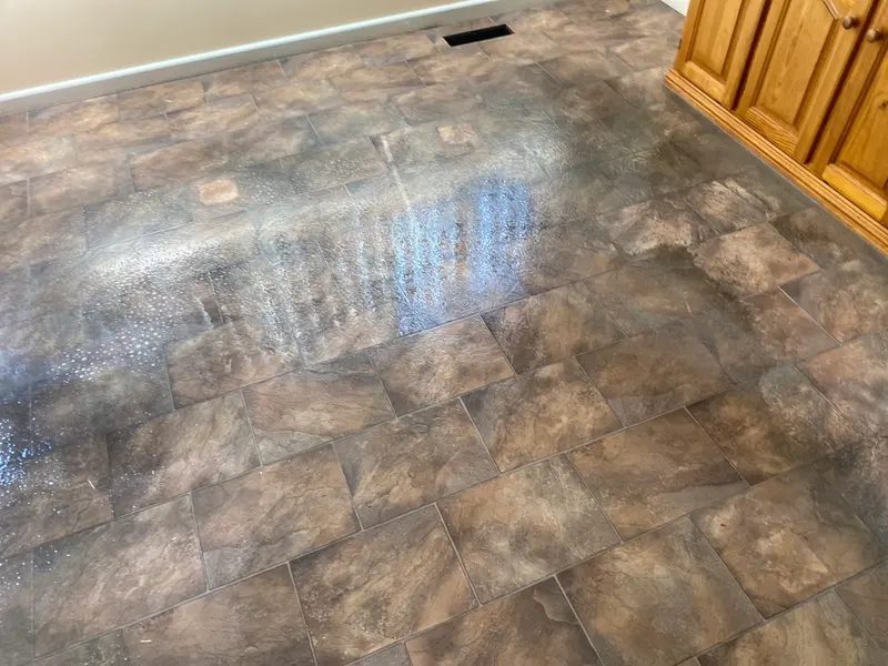 The same tile-pattern vinyl after stripping and resealing, with the dark build-up gone