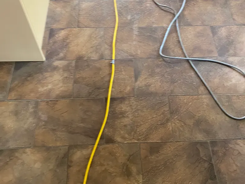 Dull, darkened tile-pattern vinyl floor before stripping in a Preston home